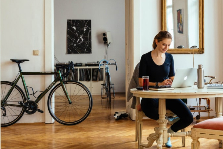 Person at desk with bicycle in the room